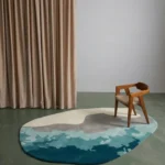 Marina Wave modern organic irregular area rug styled in a contemporary interior room with a wooden chair and beige curtains.