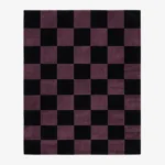 A top-down studio product photograph of a rectangular area rug featuring a classic checkered pattern in mulberry purple and black.