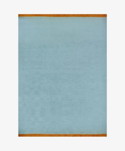 A full top-down studio shot of the rectangular Nimbus area rug, featuring a solid sky-blue wool pile with a contrasting vibrant orange fringed border on both short ends.