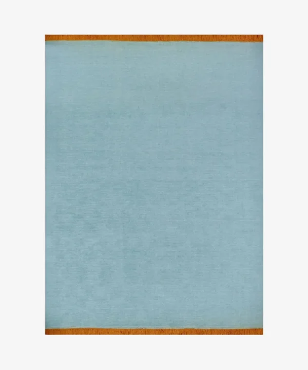 A full top-down studio shot of the rectangular Nimbus area rug, featuring a solid sky-blue wool pile with a contrasting vibrant orange fringed border on both short ends.