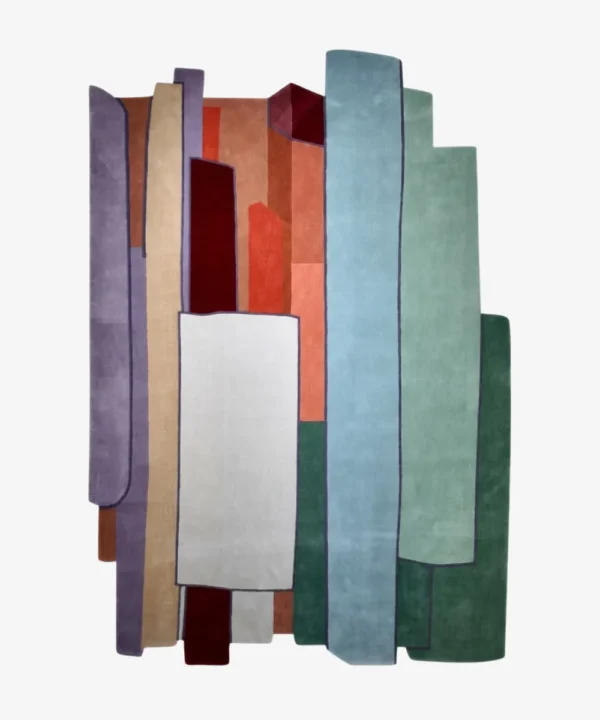 A top-down studio product photograph of the rectangular Prism Verin area rug, featuring an abstract geometric composition with vertical panels in shades of purple, rust, blue, and green.