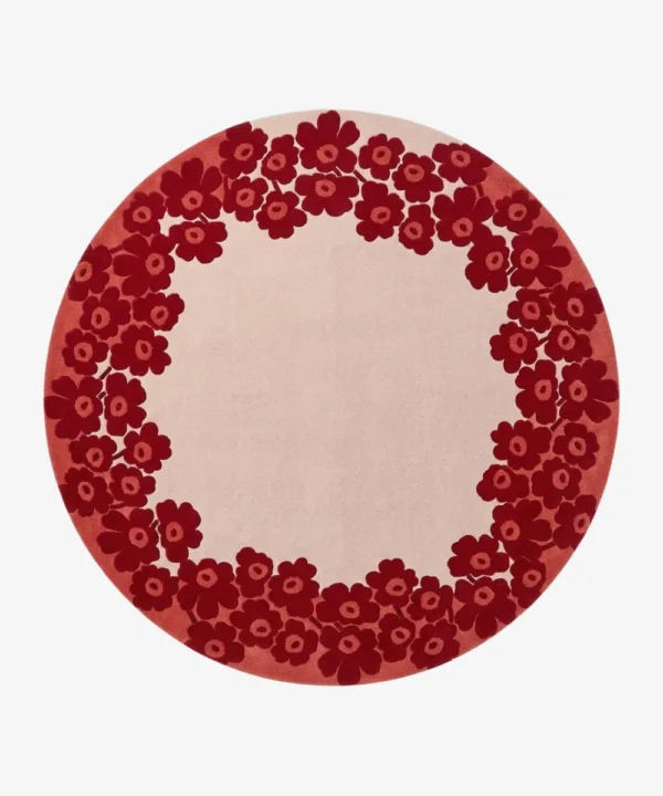 Full top-down product isolated shot of the round Rosara area rug, featuring a dense outer ring pattern of retro stylized poppy flowers in deep crimson red over a solid off-white center field and muted rose pink perimeter.