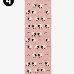 Top-down view of a rectangular pink wool runner rug decorated with a repeating pattern of black and white sheep and small heart icons.