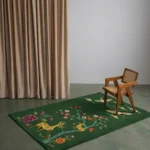 Verdanis forest green tufted rug styled in a modern interior setting with a wooden chair and beige curtains.