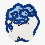 Amora blue floral organic shaped tufted area rug featuring interconnected blue floral patterns and white color blocking, displayed flat.