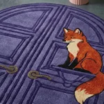Angle close-up view of the handmade Foxmere arch rug highlighting the sitting fox detail and textured door handle motifs.
