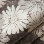 Close-up of the plush tufted pile texture, carved floral details, and neutral grey-and-cream color tones on the Petalitho rug.