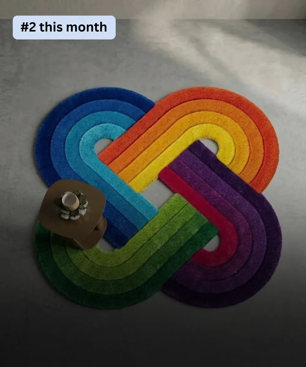 Vibrant rainbow infinity loop shaped tufted area rug with bright color-blocked gradient rings displayed on a modern grey floor.