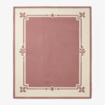 Rosaine pink and cream rectangular area rug featuring an elegant bordered geometric and floral corner design, displayed flat.
