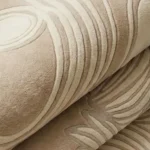 Folded view of the Tidewave tufted rug highlighting the high-density plush wool pile and intricate carved wave line details.