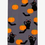 Studio flat-lay product photograph of the rectangular Paws & Pumpkins rug on a clean background, showcasing the grey wool field patterned with cute black cats, orange pumpkins, and flying bats.