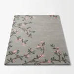 Studio flat-lay product photograph of the rectangular Sakura Branch rug on a clean white background, showcasing the full sage-grey field with branching pink flowers and green leaves.